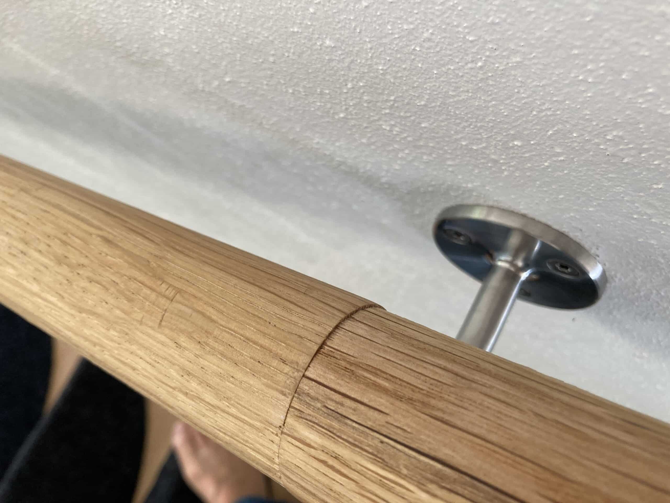 Wandmontierter Handlauf in einer Innentreppe, bei der die Konsolen in Ständer oder einer dahinterliegenden tragenden Platte verankert werden müssen