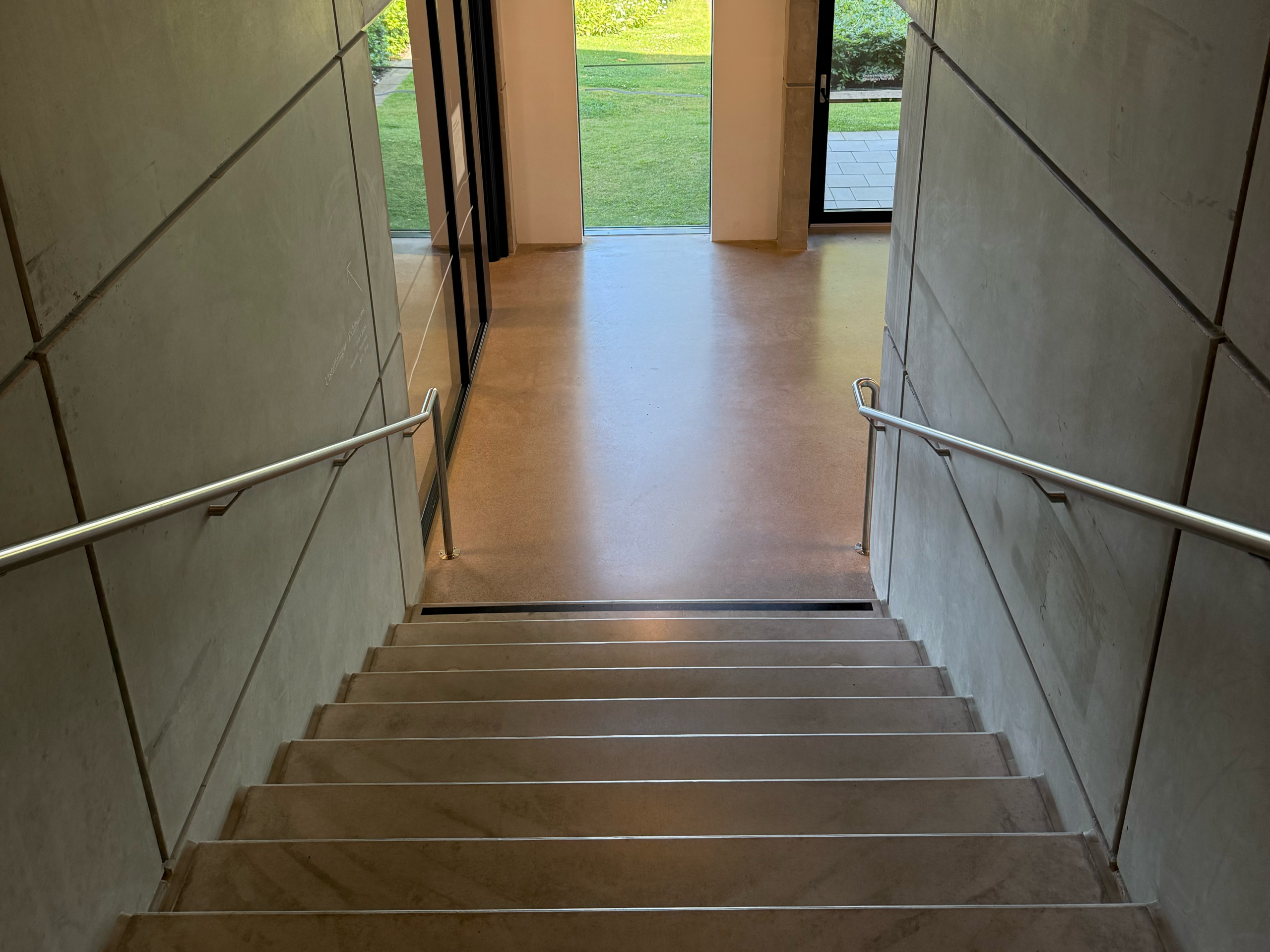 Edelstahl-Handlauf, montiert an einer Betontreppe, wobei die Befestigung an die Betonqualität und den Randabstand angepasst werden muss
