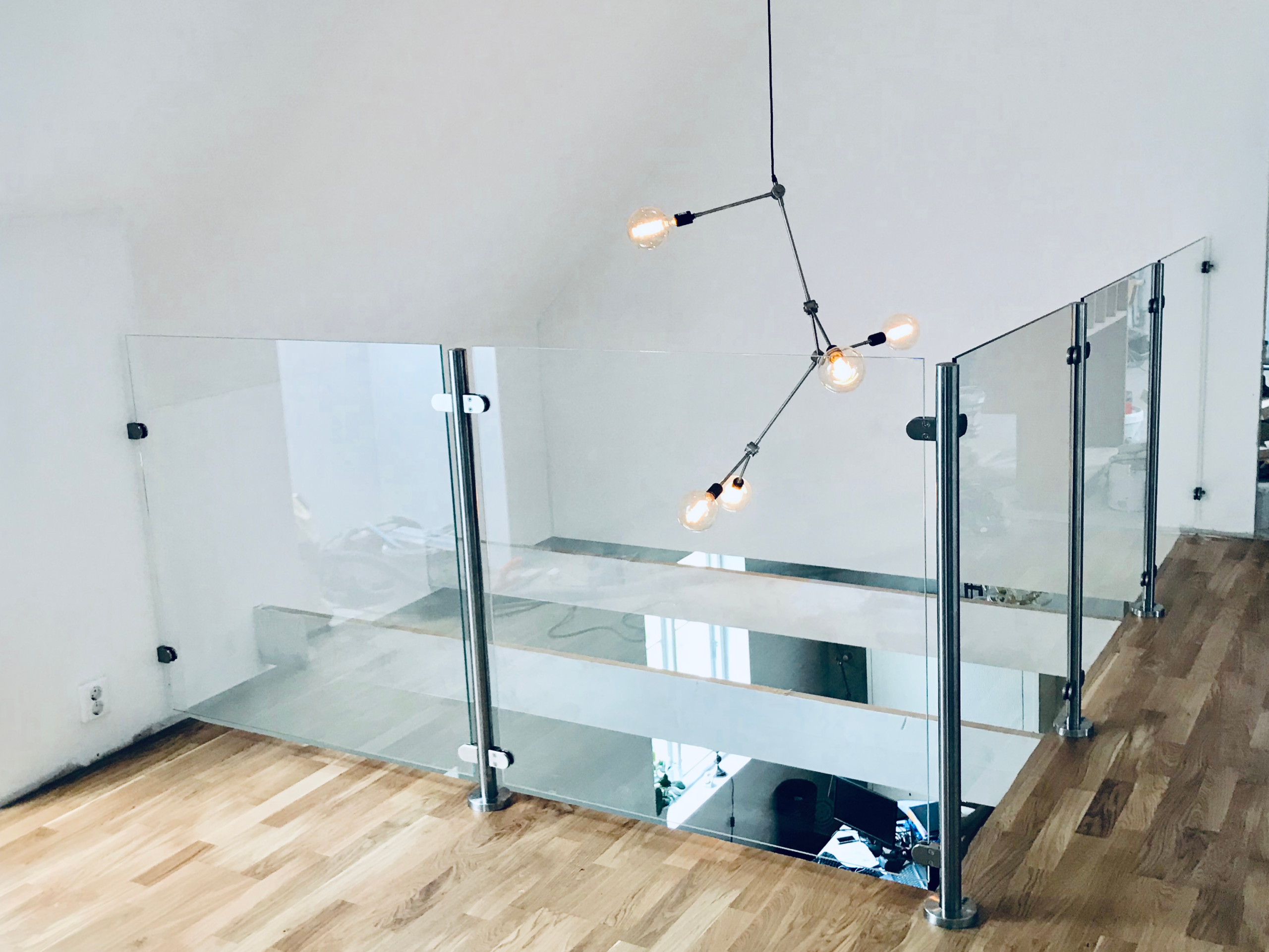 Glasgeländer am Loft und an der Treppenöffnung, das Licht zwischen den Etagen hindurchlässt.