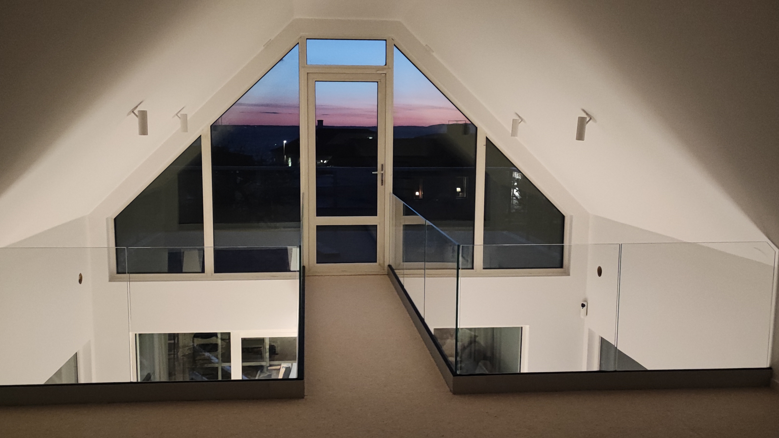 Indoor glass railing in an open-concept loft with plenty of light and space.